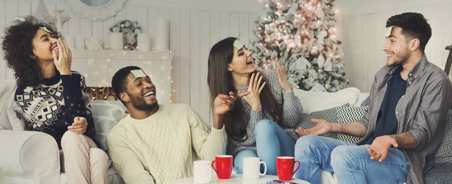 Freunde lachen bei einem Weihnachtsspiel